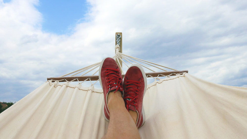 de-stressed person sits in a hammock relaxing